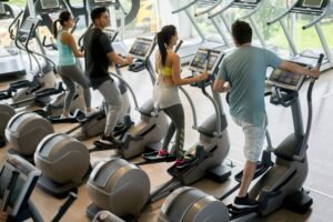 elipsiniai treniruokliai žmonės sportuoja salėje